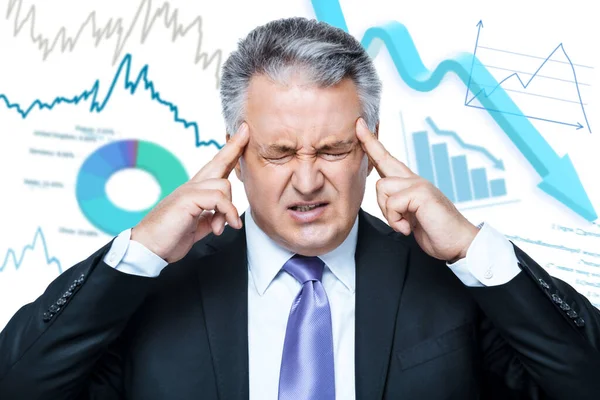 Coronavirus COVID-19 and market crash. Stressed businessman or investor suffering from headache while standing against background with financial graphs and charts. Coronavirus crisis. Web banner
