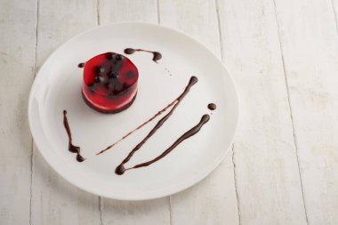 üzümü üzerinde beyaz bir plaka üzerinde bir bisküvi ile jöleli pasta