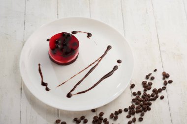 üzümü üzerinde beyaz bir plaka üzerinde bir bisküvi ile jöleli pasta