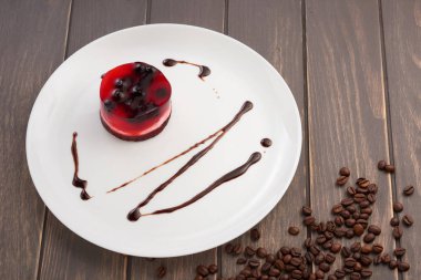 üzümü üzerinde beyaz bir plaka üzerinde bir bisküvi ile jöleli pasta