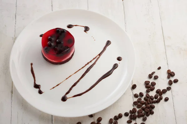 jelly cake with currant on a biscuit on a white plate