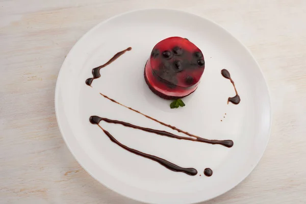 jelly cake with currant on a biscuit on a white plate