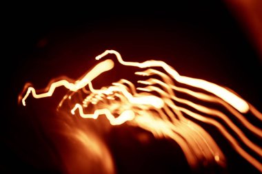 Işık koyu arka plan üzerinde kırmızı soyut yollar. Uzun pozlama.