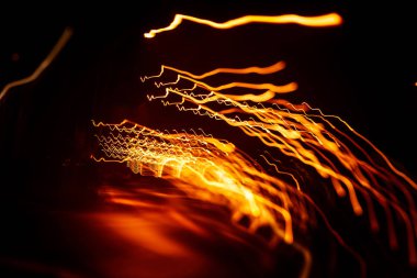 Işık koyu arka plan üzerinde kırmızı soyut yollar. Uzun pozlama.