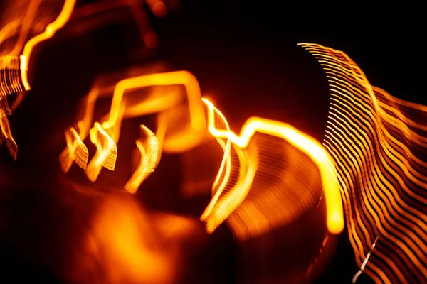 Işık koyu arka plan üzerinde kırmızı soyut yollar. Uzun pozlama.