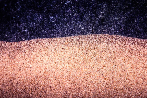Ein abstrakter, kontrastreicher Hintergrund aus Sand und Felsen. flache Schärfentiefe, lila Farbton. — Stockfoto