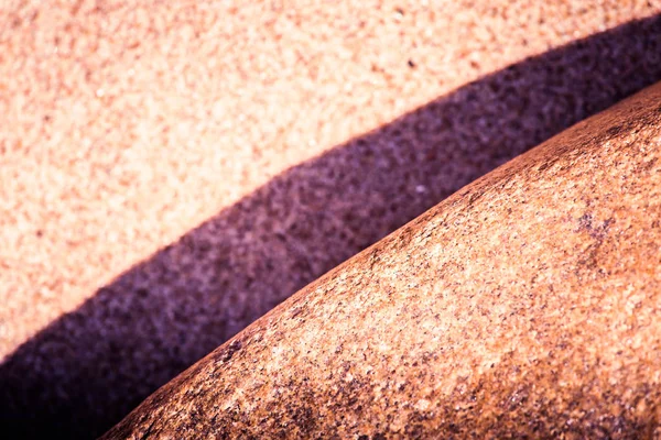 Um fundo abstrato de alto contraste de uma areia do mar e formas de rocha. Profundidade rasa do campo, tom de cor roxo . — Fotografia de Stock