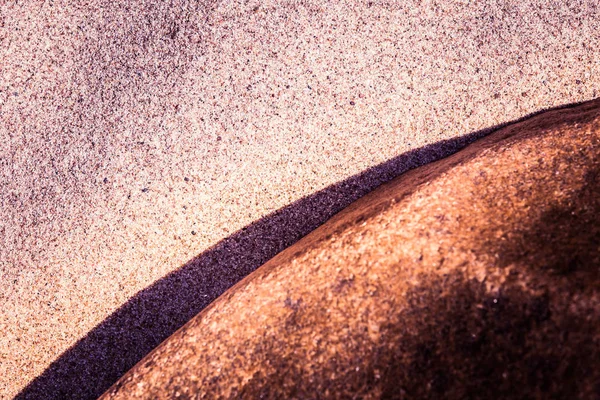 De achtergrond van een abstracte, hoog contrast van een zee zand en rock vormen. Diepte van het veld ondiep, paarse kleurtoon. — Stockfoto