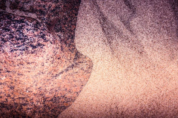 Un fondo abstracto y de alto contraste de arena marina y formas rocosas. Profundidad superficial del campo, tono de color púrpura . — Foto de Stock