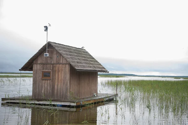 Un bellissimo paesaggio di casa in un lago con sponde erbose — Foto Stock