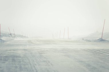 Norveç kışın Emanet direkleri olan beyaz, karlı yol ile güzel bir manzara