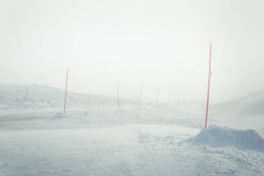 Norveç kışın Emanet direkleri olan beyaz, karlı yol ile güzel bir manzara