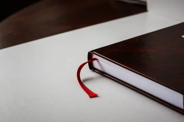 Piękny zbliżenie książki w ciemno czerwoną obwolutą i z czerwonej zakładki. Płytkiej głębi ostrości — Zdjęcie stockowe