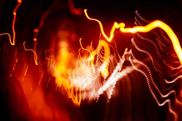 Rutas abstractas rojas de luz sobre fondo oscuro. Larga exposición . — Foto de Stock