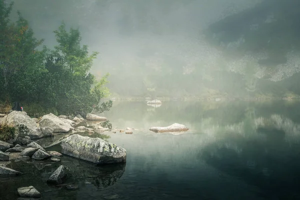Un beau lac de montagne dans un brouillard à Tatry, Slovaquie. Style rétro à faible saturation — Photo