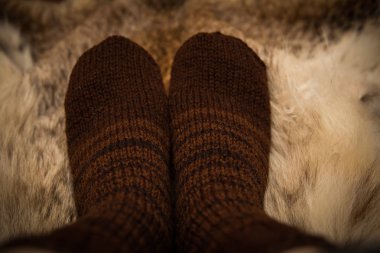 Sıcak el bir kürk zemin üzerine yün çorap ördü. İlk kişi görünümü.