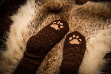 Çift el örgü yün çorap kürk arka plan üzerinde bir kedi pençe desenli