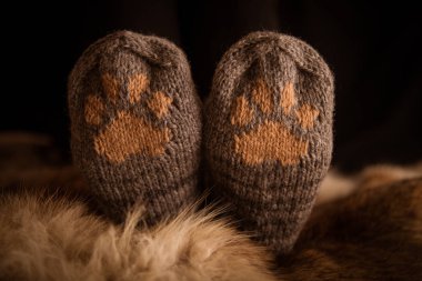 Çift el örgü yün çorap kürk arka plan üzerinde bir kedi pençe desenli