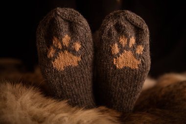 Çift el örgü yün çorap kürk arka plan üzerinde bir kedi pençe desenli