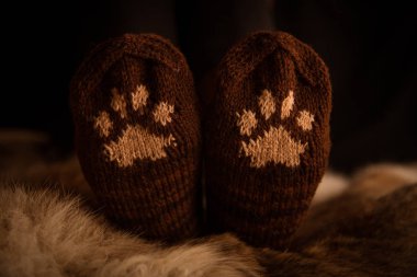 Çift el örgü yün çorap kürk arka plan üzerinde bir kedi pençe desenli