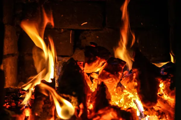 Feu brûlant à l'intérieur d'un poêle à briques bois, cendres, flammes . — Photo