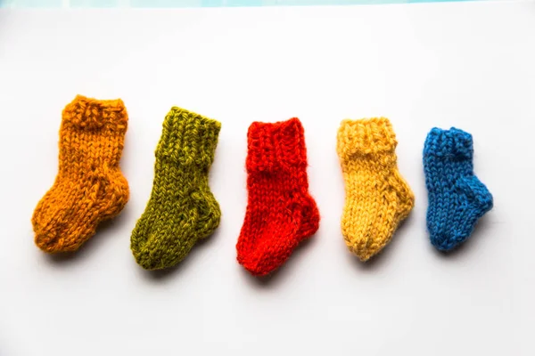 Small, hand knitted woolen socks on light background — Stock Photo, Image