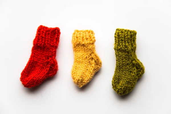 Small, hand knitted woolen socks on light background — Stock Photo, Image