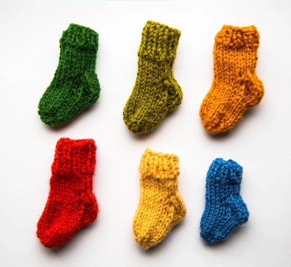 Small, hand knitted woolen socks on light background — Stock Photo, Image
