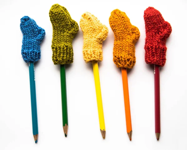Küçük, örme Yün çorap ışık arka plan üzerinde renkli kalemler ile el