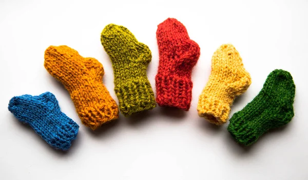 Small, hand knitted woolen socks on light background — Stock Photo, Image