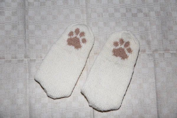Пара ручных вязаных шерстяных носков с рисунком кошачьей лапы на льняном фоне — стоковое фото