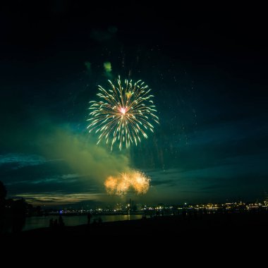 Güzel, renkli havai fişek yukarıda bir Bağımsızlık günü sırasında Nehri Riga, Letonya.