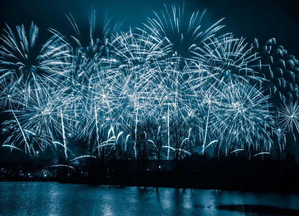 Fogos de artifício bonitos e coloridos acima do rio durante um dia de independência em Riga, Letónia . — Fotografia de Stock