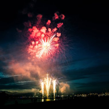 Güzel, renkli havai fişek yukarıda bir Bağımsızlık günü sırasında Nehri Riga, Letonya.