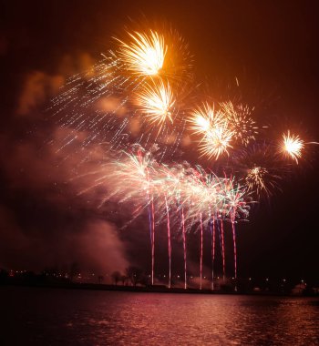 Güzel, renkli havai fişek yukarıda bir Bağımsızlık günü sırasında Nehri Riga, Letonya.