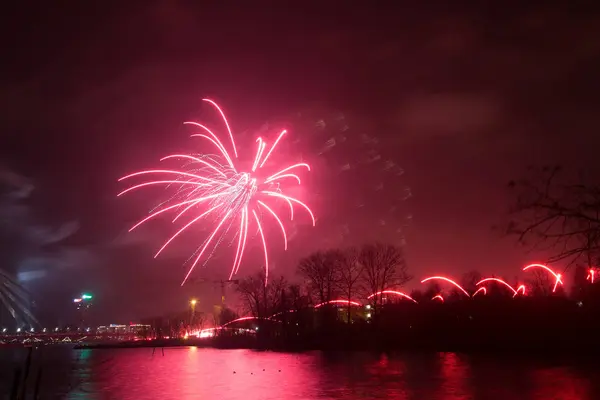 Fogos de artifício bonitos e coloridos acima do rio durante um dia de independência em Riga, Letónia . — Fotografia de Stock