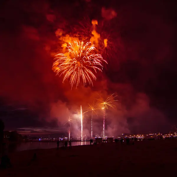 Hermosos y coloridos fuegos artificiales sobre el río durante un día de independencia en Riga, Letonia . — Foto de Stock