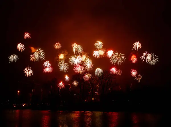 Fogos de artifício bonitos e coloridos acima do rio durante um dia de independência em Riga, Letónia . — Fotografia de Stock