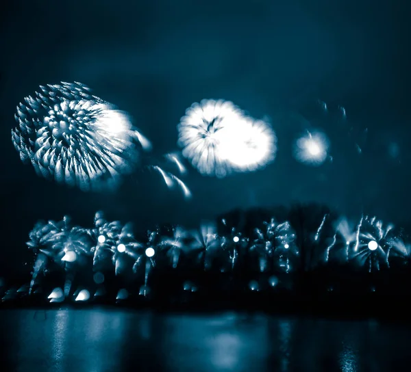 Resumen, borroso, bokeh-estilo colorido foto de fuegos artificiales en un tono azul sobre el río —  Fotos de Stock
