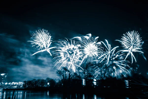 Abstraktes, verschwommenes, im Bokeh-Stil farbenfrohes Foto von Feuerwerk in blauem Ton über dem Fluss — Stockfoto