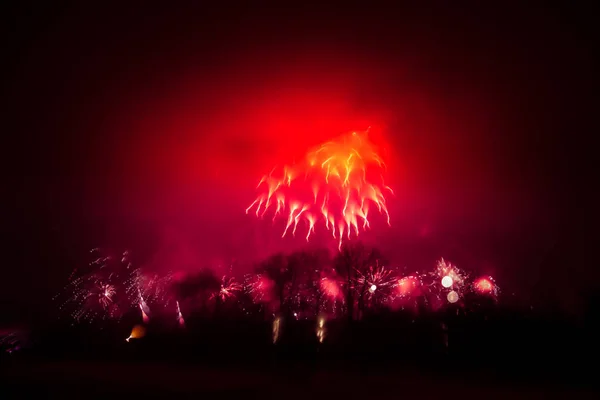 Abstrato, borrado, bokeh-estilo colorido foto de fogos de artifício em um tom vermelho acima do rio — Fotografia de Stock