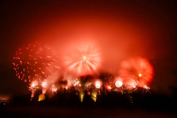 Abstrato, borrado, bokeh-estilo colorido foto de fogos de artifício em um tom vermelho acima do rio — Fotografia de Stock