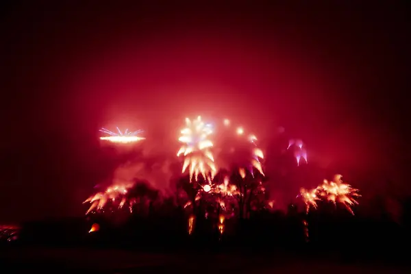 Abstrato, borrado, bokeh-estilo colorido foto de fogos de artifício em um tom vermelho acima do rio — Fotografia de Stock