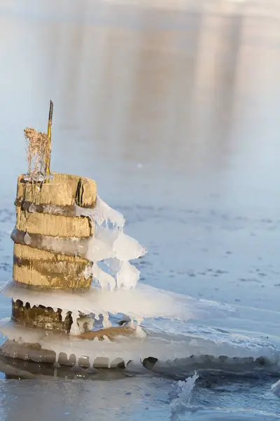 Eau gelée sur de vieux poteaux brise-eau — Photo