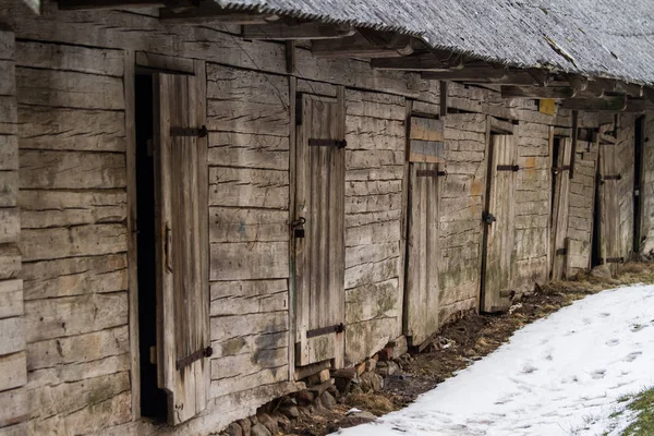 Un antiguo edificio de madera en un paisaje invernal — Foto de Stock