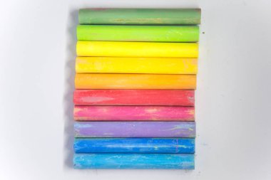 Canlı renkli tebeşir beyaz kağıt üzerine yapışır. Güzel okul malzemeleri. Beyaz bir arka plan üzerinde tebeşir.