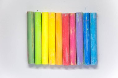 Canlı renkli tebeşir beyaz kağıt üzerine yapışır. Güzel okul malzemeleri. Beyaz bir arka plan üzerinde tebeşir.