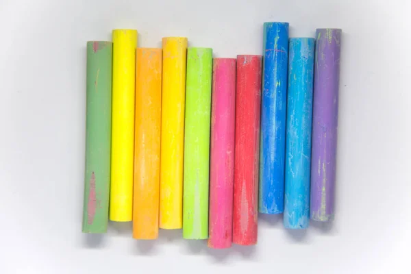 Vivid colorful chalk sticks on a white paper. Beautiful school supplies. Chalk on a white background. — Stock Photo, Image