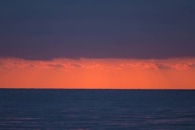 Baltık denizde sakin bir gün batımı. Sonbahar akşam plajda. Güneş ve deniz ufuk. Bir deniz renkli bir manzara.