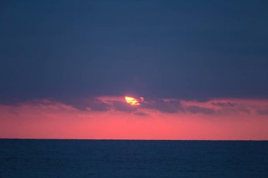 Baltık denizde sakin bir gün batımı. Sonbahar akşam plajda. Güneş ve deniz ufuk. Bir deniz renkli bir manzara.